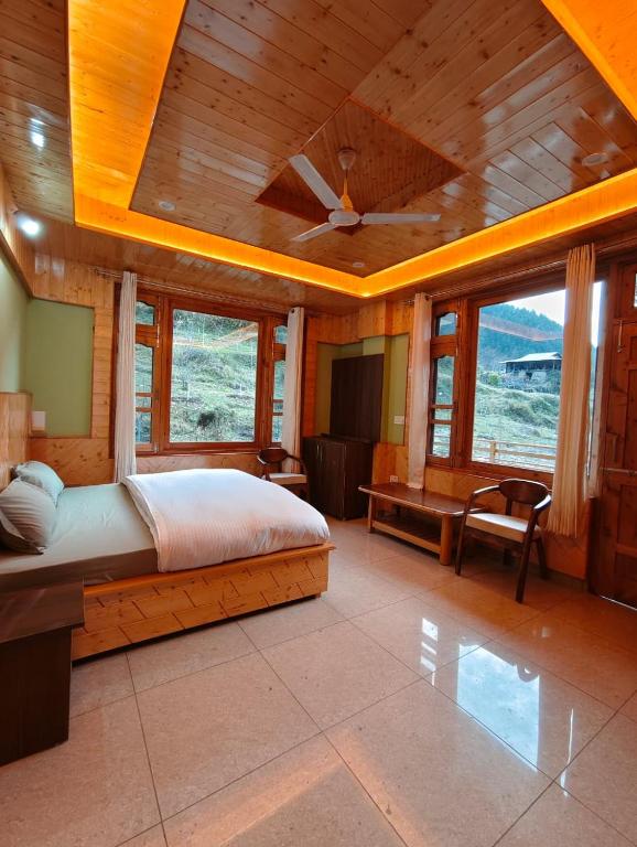 a bedroom with a bed and a ceiling fan at Himalayan Hideaway Homestay in Kasol