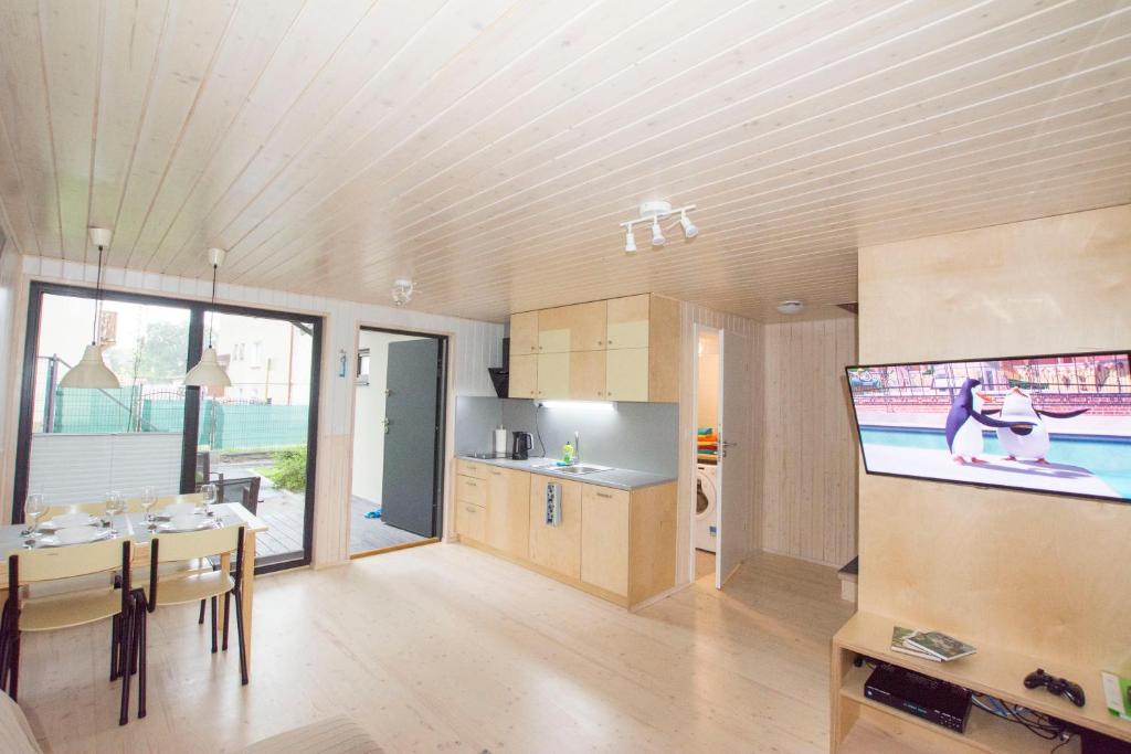 eine Küche und ein Esszimmer mit einem Flachbild-TV in der Unterkunft Domki KREDKA in Jastarnia