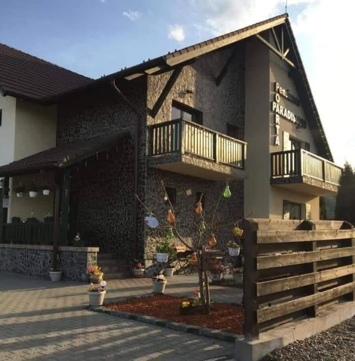 a building with two balconies on the side of it at Casa Poarta Paradisului in Moldoveneşti