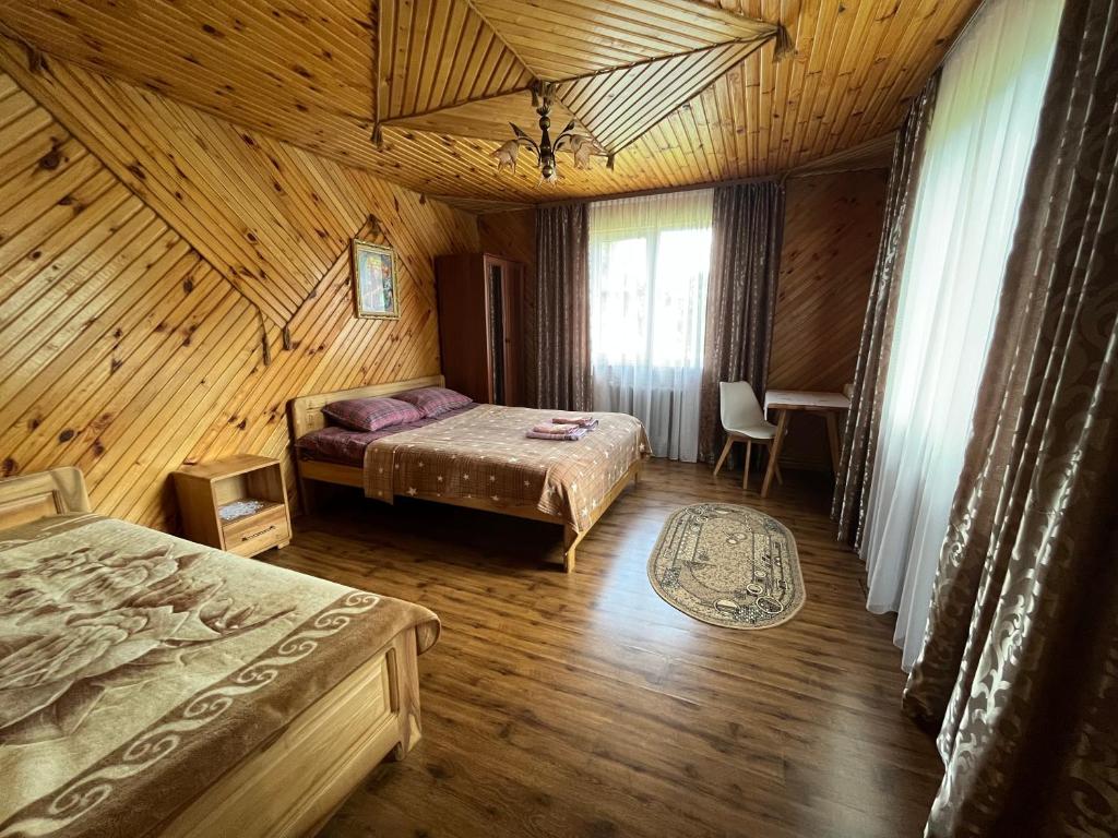 a bedroom with two beds in a wooden cabin at Затишний дім in Yaremche