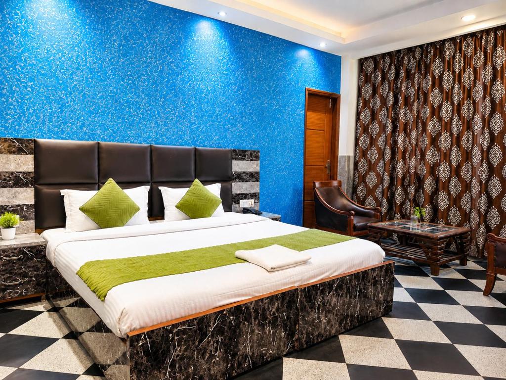 a bedroom with a large bed and a blue wall at Hotel Orchid Garden Karol Bagh in New Delhi