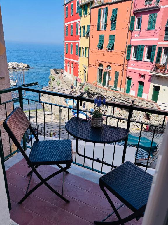 a balcony with a table and chairs and the ocean at Life Class Apartment in Riomaggiore