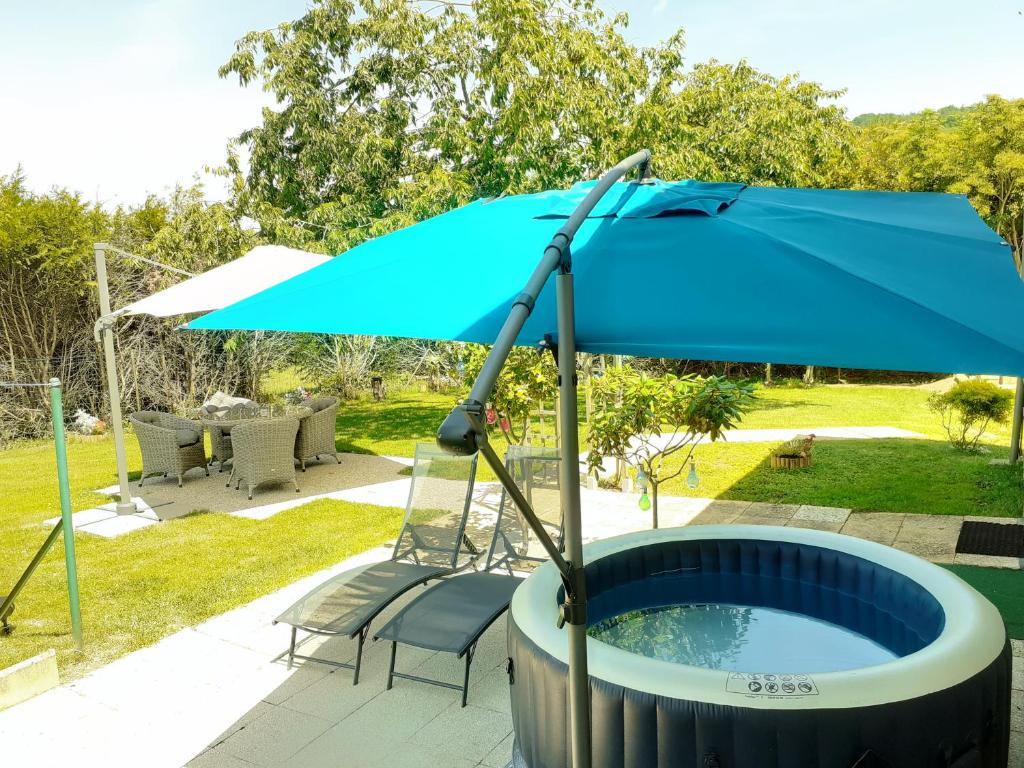 a blue umbrella sitting next to a pool at Gîte pres de Giverny in Gasny