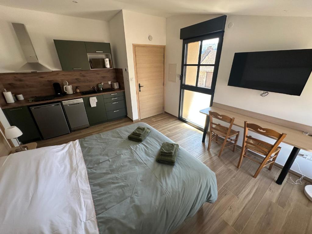 a room with a bed and a flat screen tv at Appartement PICHOLINE in Saint-Sorlin-en-Bugey