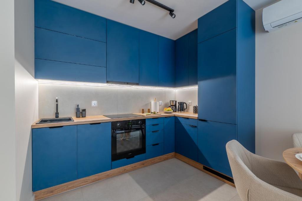 a blue kitchen with white walls and blue cabinets at Navy Blue Apartment - SPA - Basen - Parking in Dziwnów