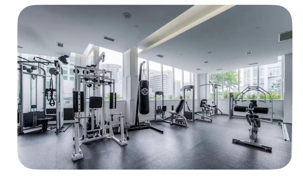 a gym with treadmills and machines in a building at Urban Nest in Toronto