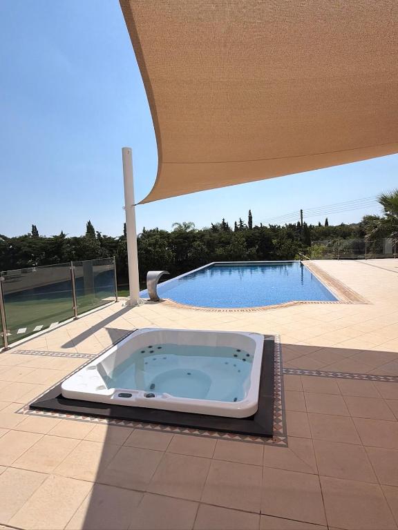 a hot tub sitting on a patio next to a pool at The Sea Breeze in Paralimni