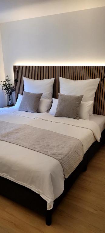 a large bed with white sheets and pillows at O'Schwarzwald in Münstertal