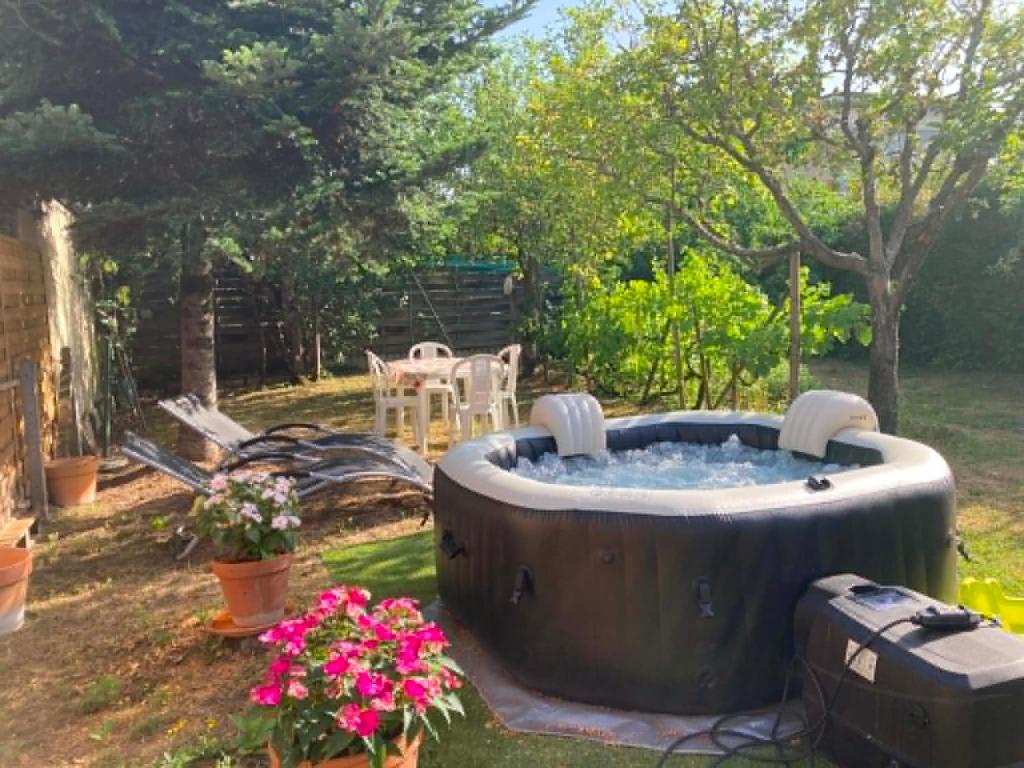 a large hot tub in a yard with flowers at villa des roses in Bergerac