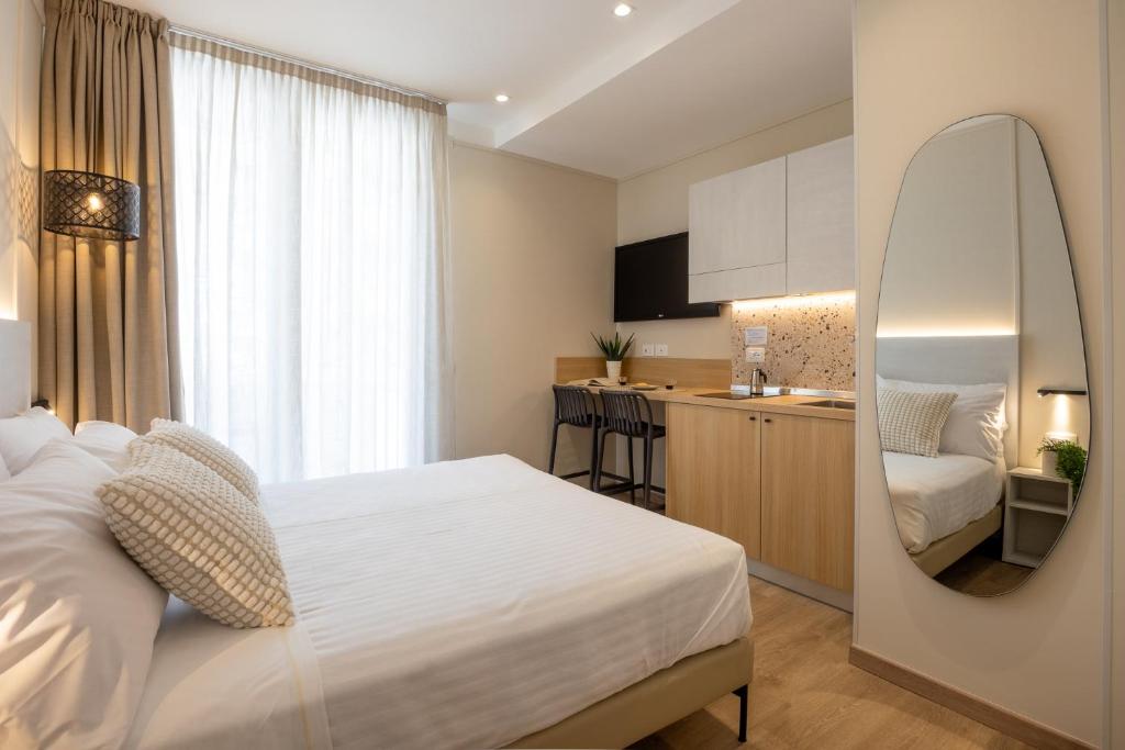 a bedroom with a white bed and a kitchen at Casa Bellariva in Cattolica