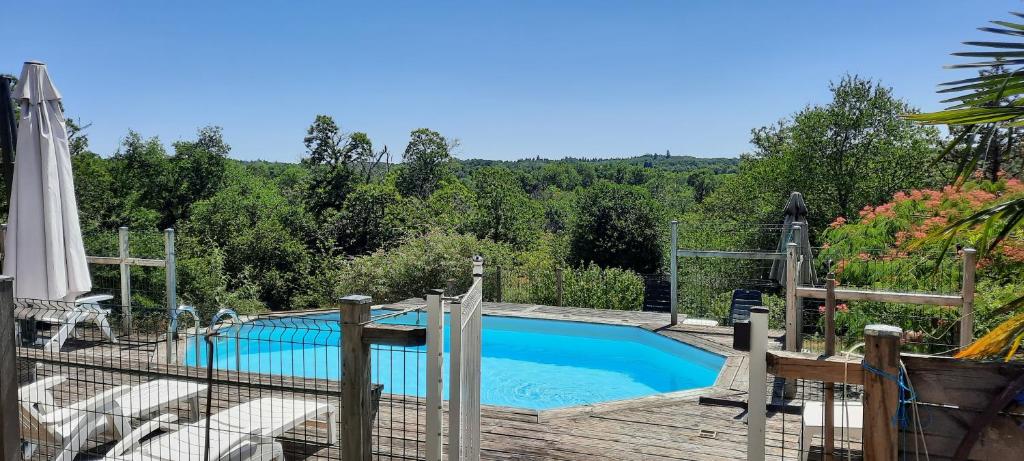 a swimming pool with chairs and a fence around it at maison infini in Les Salles-Lavauguyon