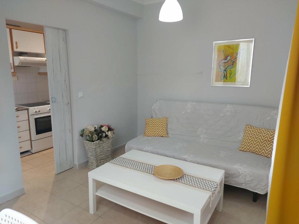 a living room with a white couch and a table at Velvet in Perea