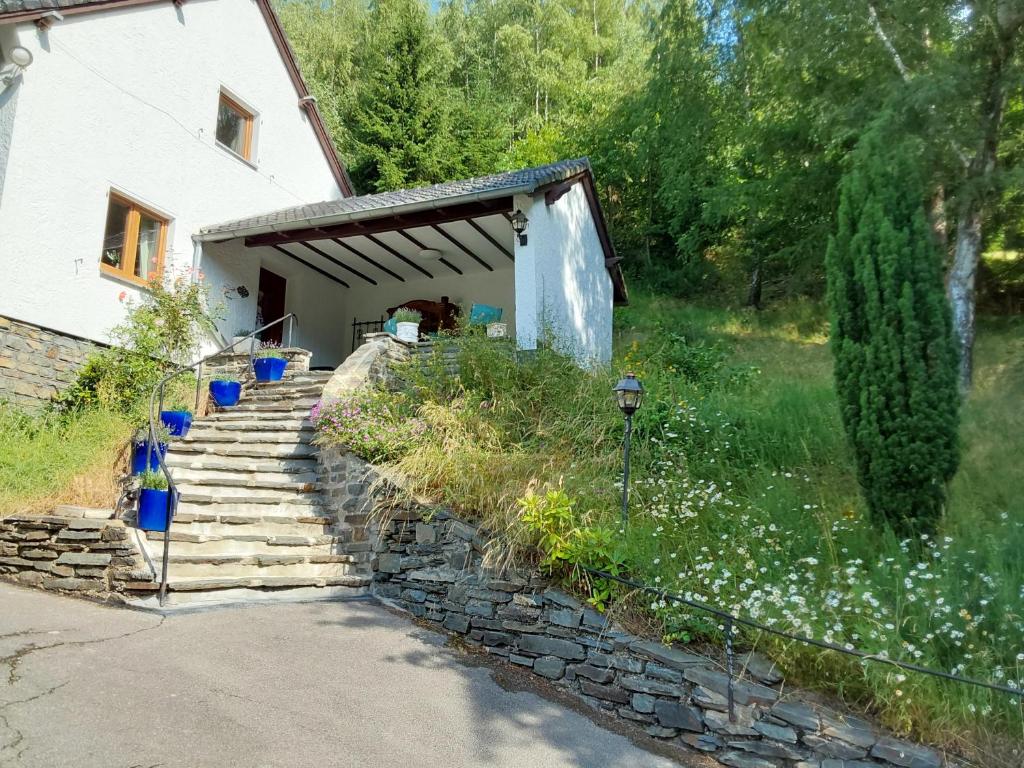 a house with a stone staircase next to a building at Eifel Waldhaus in Simmerath