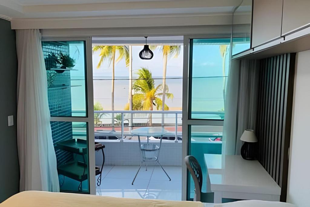 a bedroom with a view of the ocean from a balcony at Blue Sunset Prime vista do mar e varanda in João Pessoa