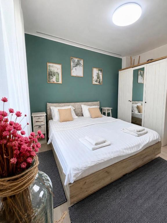 a bedroom with a large bed with white sheets at Casa Family in Eforie Sud