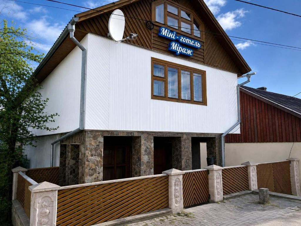 a large white building with a sign on it at Міні-готель Міраж in Yasinya