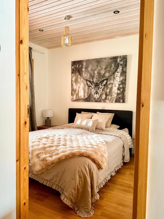 a bedroom with a bed and a picture of a deer at Silver Lodge in Luosto