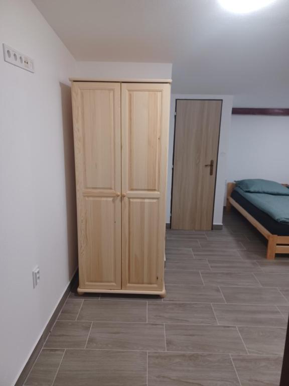 a room with two wooden cabinets and a bed at Rekreačná chata TERASA in Železničná Stanica Šiatoroš