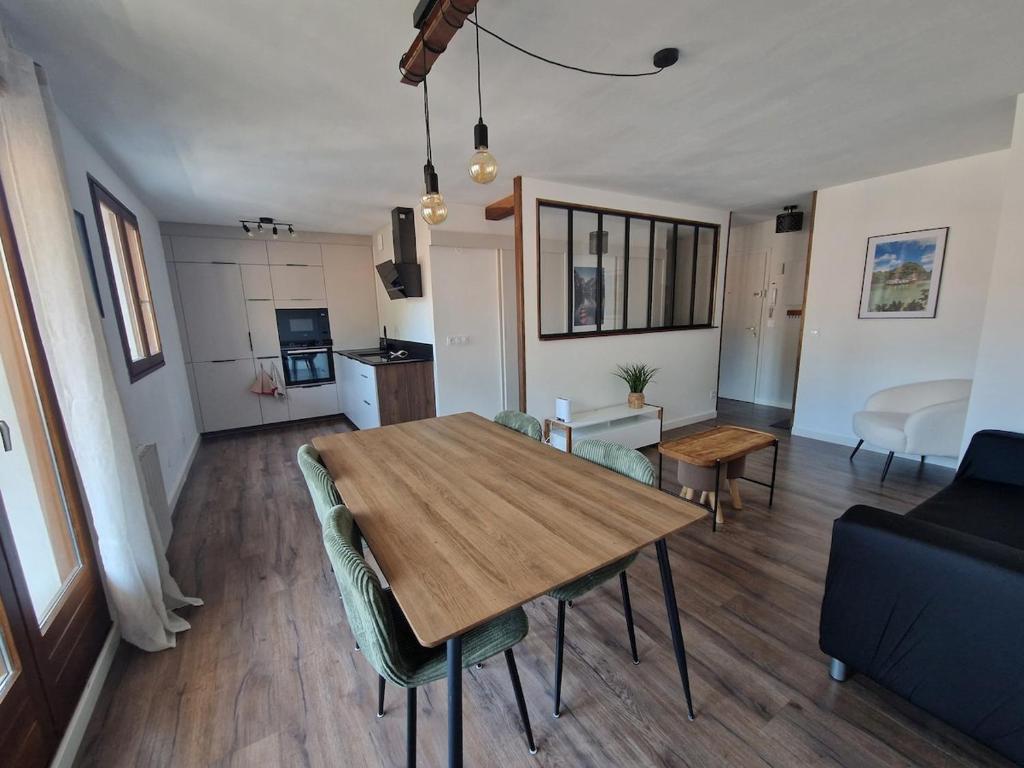 a dining room and living room with a table and chairs at Appartement Pila - Faverges in Faverges