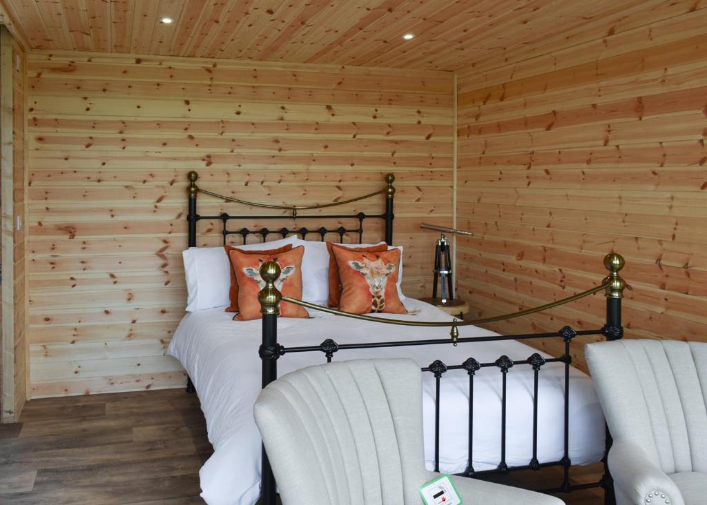 a bedroom with a bed and two chairs at Fine Country Stays in Bubwith