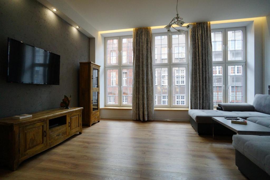 a living room with a couch and a flat screen tv at Apartament MARIACKA 42 in Gdańsk