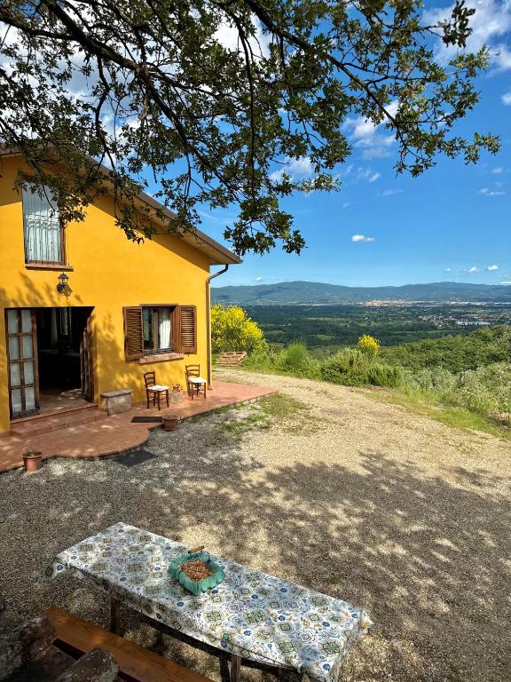 a yellow house with a picnic table in front of it at La Casa nel Bosco in Arezzo