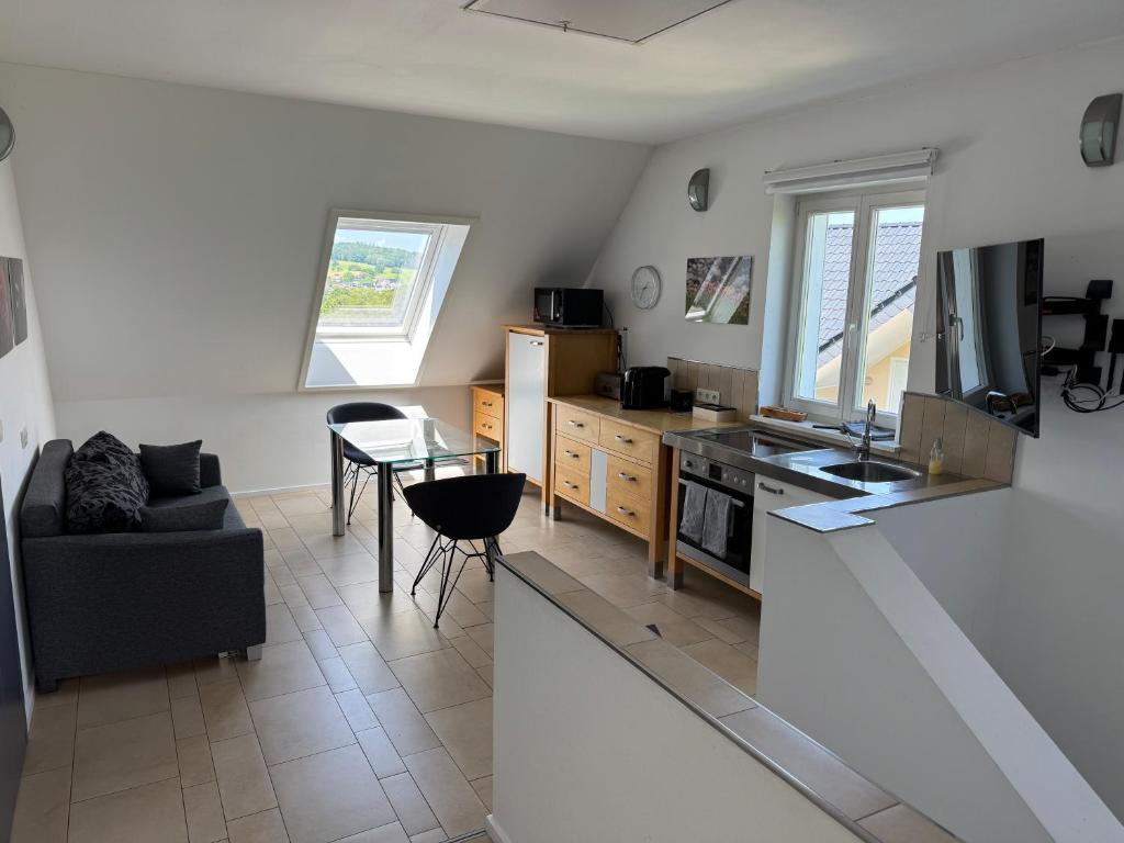 a living room with a table and a kitchen at Flat 39 in Wiehl