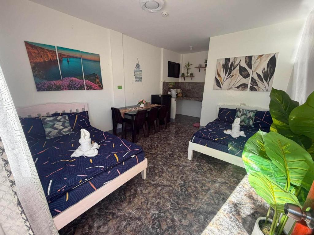 a living room with two beds and a dining room at Itawis Resort - Ivanna's Room in Silang