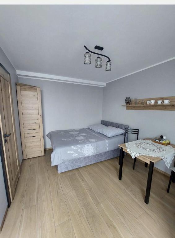 a bedroom with a bed and a table in it at Domki, pokoje, apartamenty Agata Kunowska in Ostrzyce