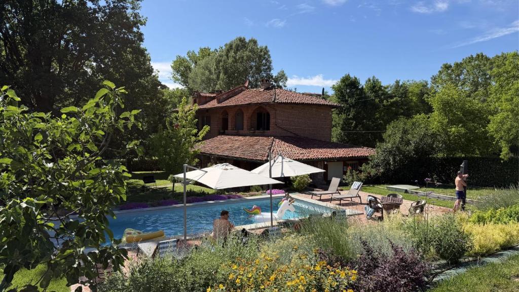 a pool in front of a house with a building at Casa Ambrogina in Agliano Terme