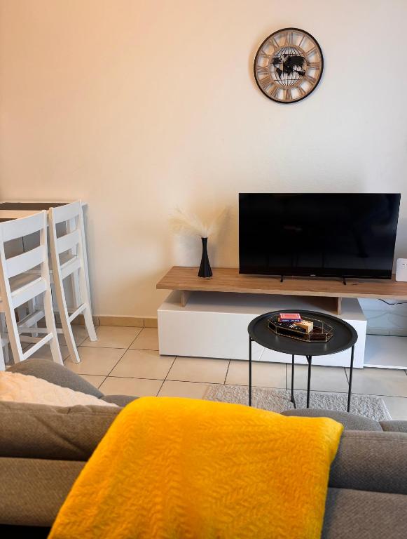 a living room with a tv and a table at Duplex cosy au cœur de Sinnamary, fleuve à pied- Samélé House in Sinnamary