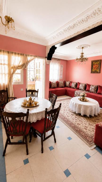 a living room with a table and a red couch at Appt Spacieux, Confortable, Calme, et Lumineux, Proche de la Plage avc Fibre Optique in Safi