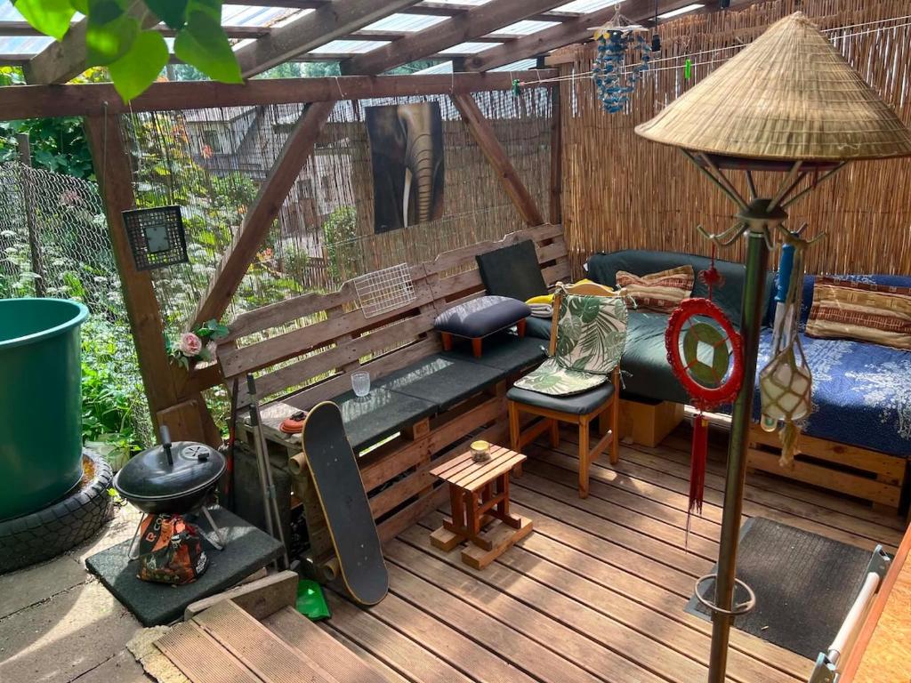 a deck with a bench and a bed and a table at Unique and private summer apartment in Tartu