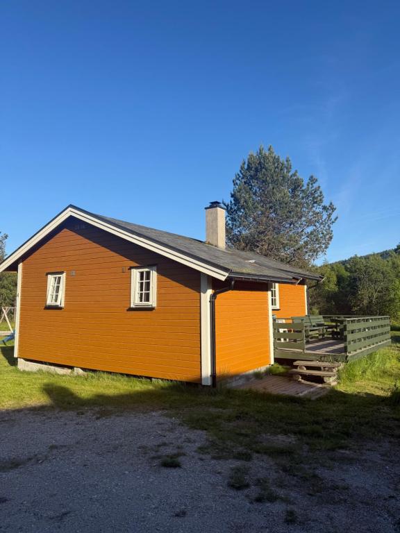 an orange house with a fence in front of it at Hafslo hytteutleige Straumane in Luster