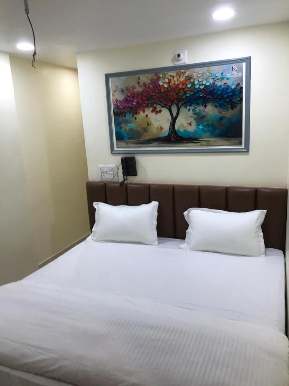 a bedroom with a bed with a painting on the wall at Hotel keshri Nandan in Nāgaur