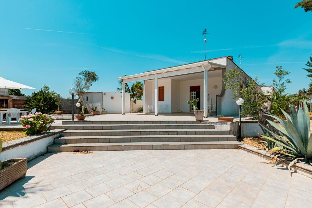 a house with stairs and a building with a porch at Baglivi's Flat in Torre Specchia Ruggeri