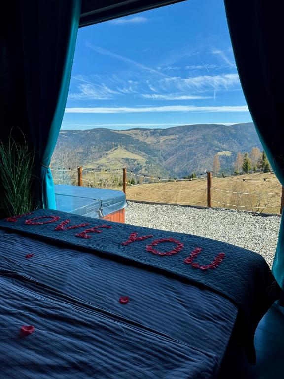 a bed in a tent with a view of the mountains at Old Man's Cabin in Măguri