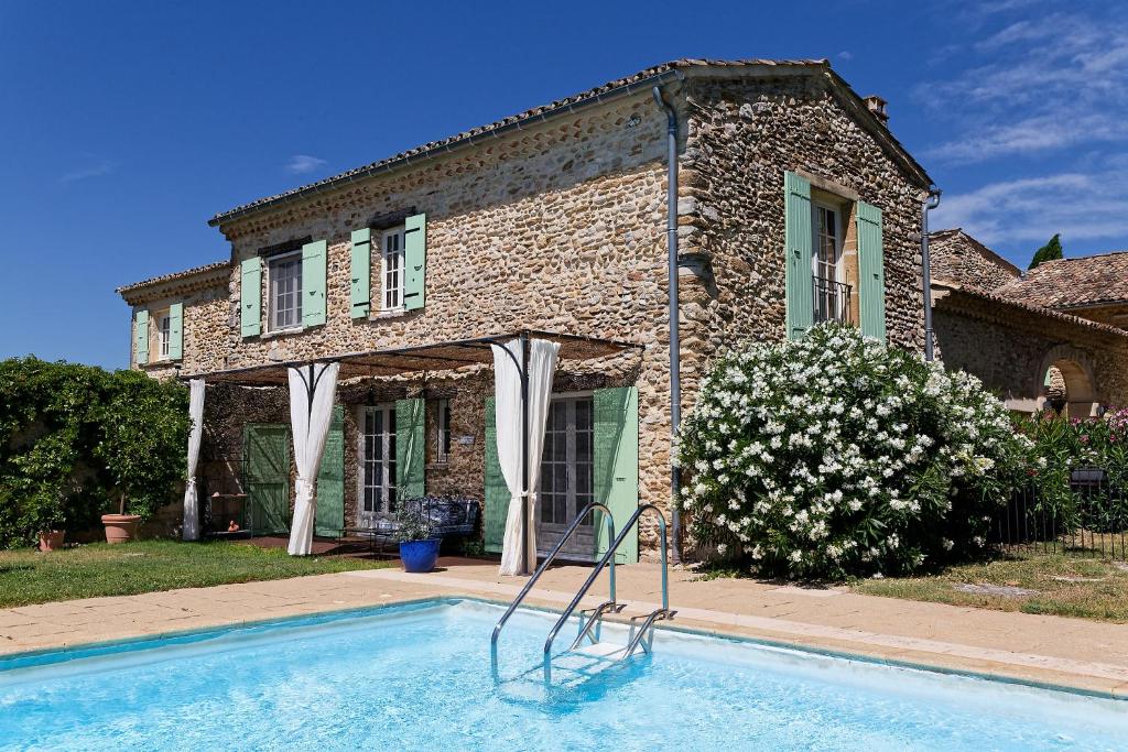 a house with a swimming pool in front of a house at Mastignac Chambre d'hôte in Valréas