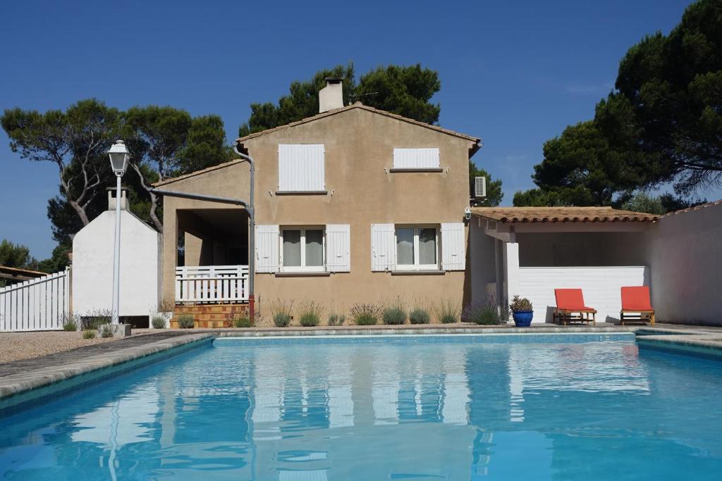 a house and a swimming pool in front of a house at Chambre dans maison provençale avec piscine in Cavaillon