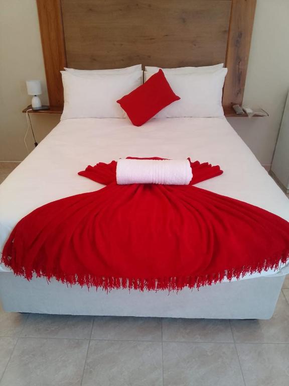 a bed with a red and white blanket on it at River Gates Guesthouse in Rundu