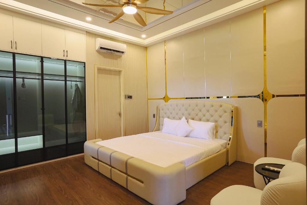 a bedroom with a white bed with a ceiling at Celestia Hue Villa in Hue