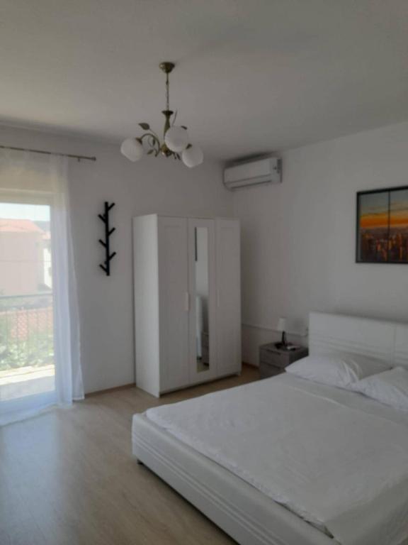a white bedroom with a bed and a window at Villa Marina in Poljica