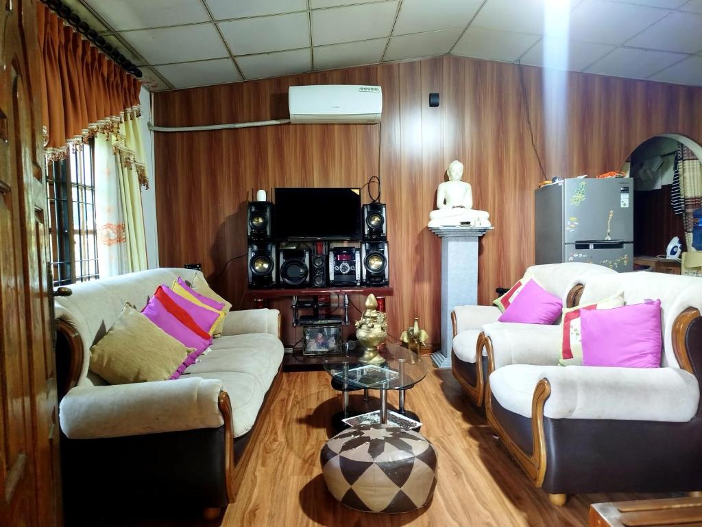 a living room with two couches and a television at Mount crest homestay in Kandy