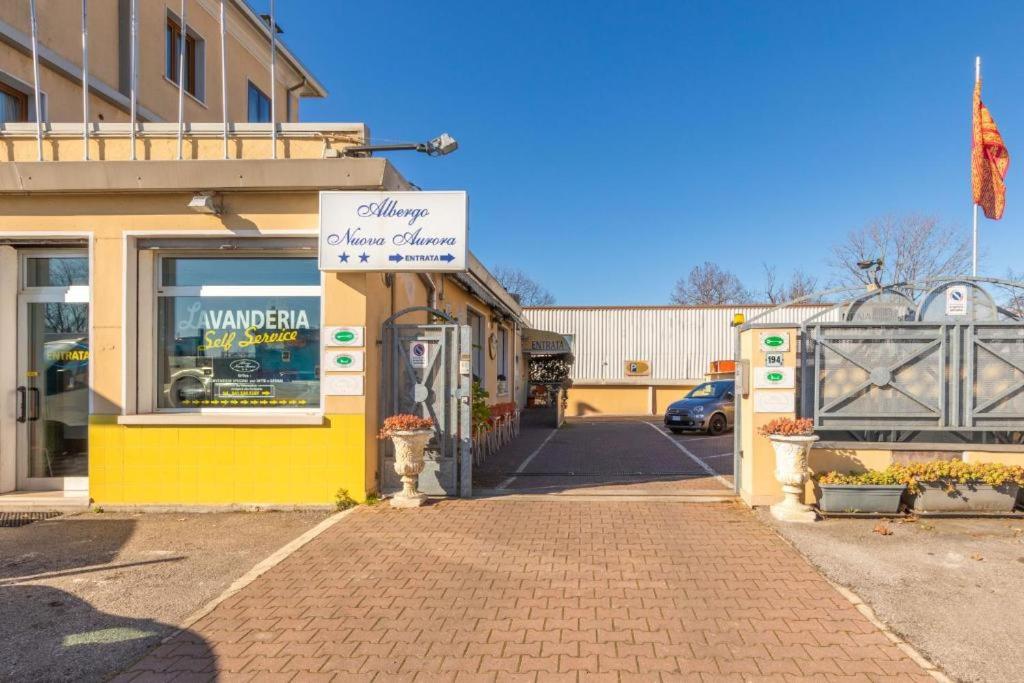 a yellow building with a sign on a street at Albergo Nuova Aurora - FREE PARKING & BREAKFAST in Marghera