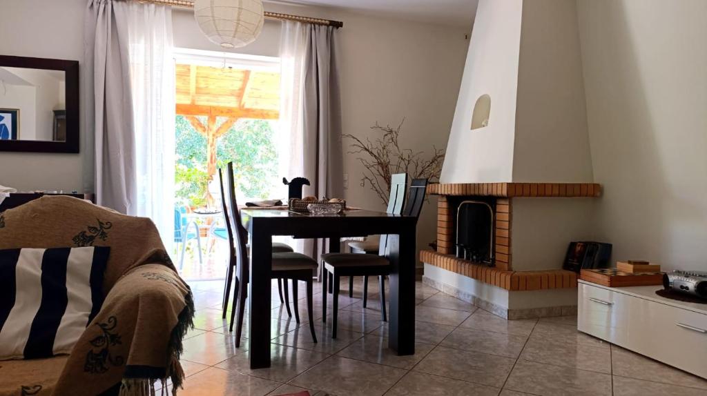 a dining room with a table and a fireplace at Anavyssos Serenity Villa in Anavyssos