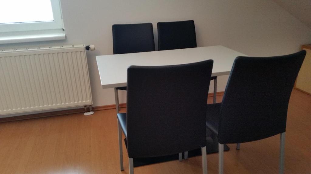 una sala de conferencias con una mesa blanca y 4 sillas en Gästehaus Daniela, en Schwanenstadt