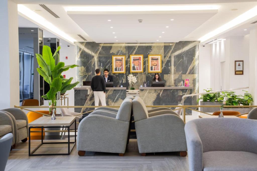 a lobby of a hotel with chairs and a reception desk at Golden Tulip Amman in Amman