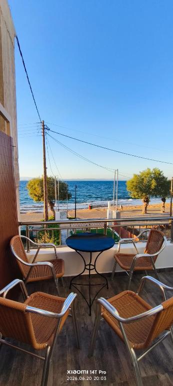 a patio with chairs and a table and the ocean at Green Boat House in Skala