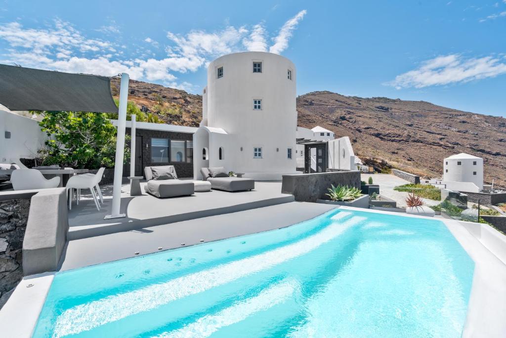a villa with a swimming pool and a house at Topos Exclusive Santorini in Imerovigli