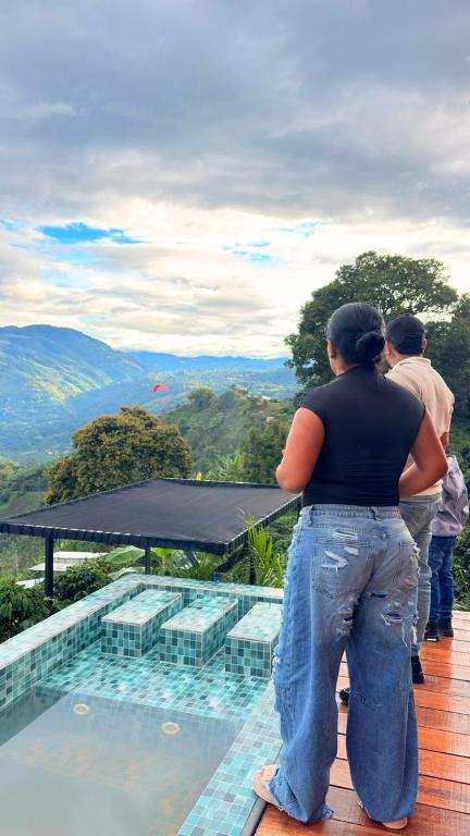 a woman standing on the edge of a building looking out at the mountains at Montecielo in Pitalito